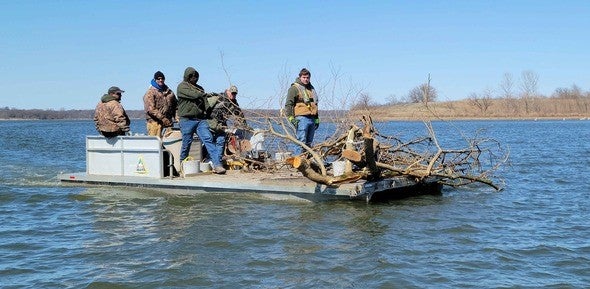Staff sink tree branches into Smithville Lake for fish habitat