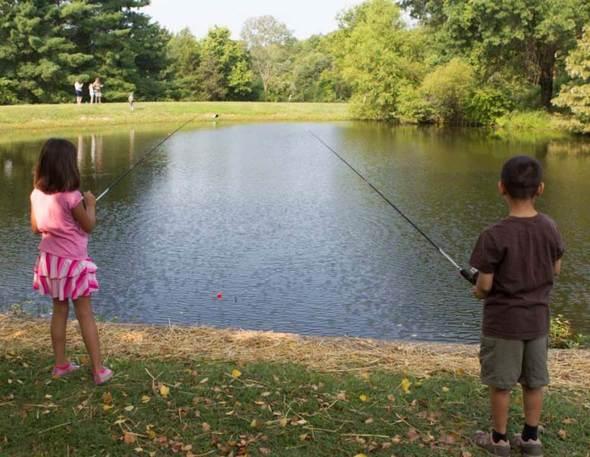 Two children fishing at a pond.