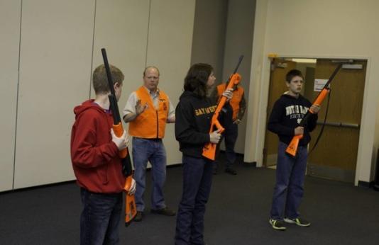 MDC staff teach a group of hunter ed students about firearm safety.