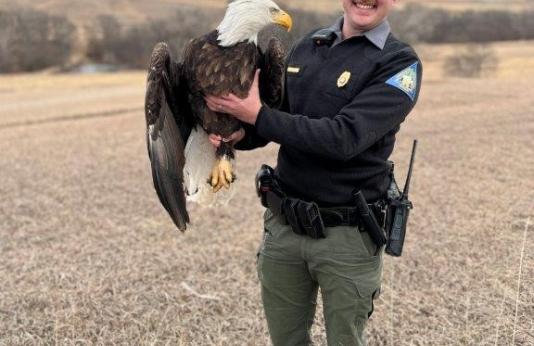 Conservation Agent Kyle Dick holding eagle