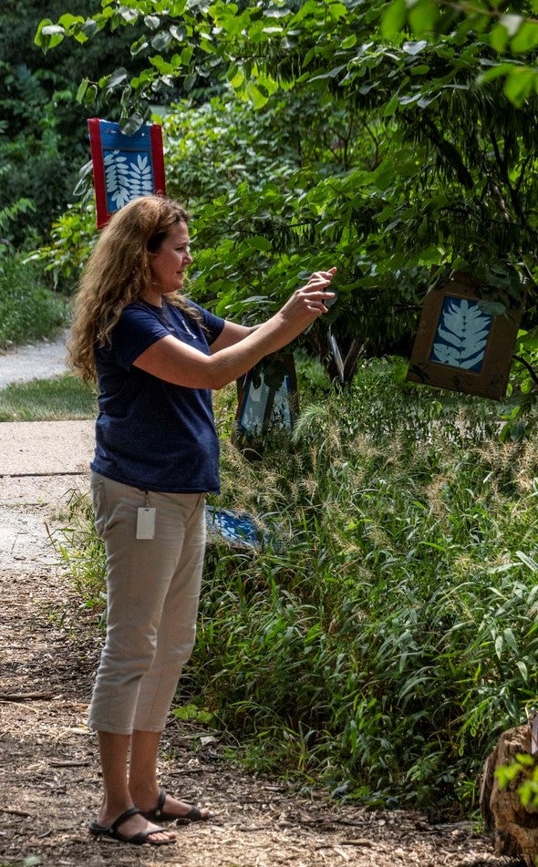Woman using iNaturalist app
