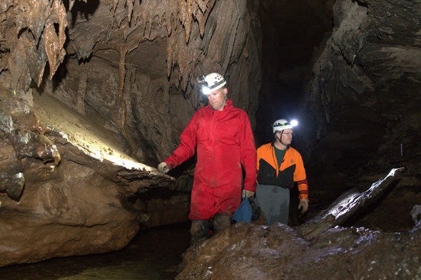 two men explore a cave