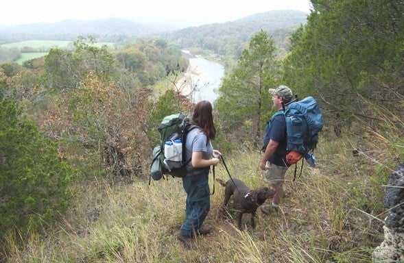 Couple backpacks with dog