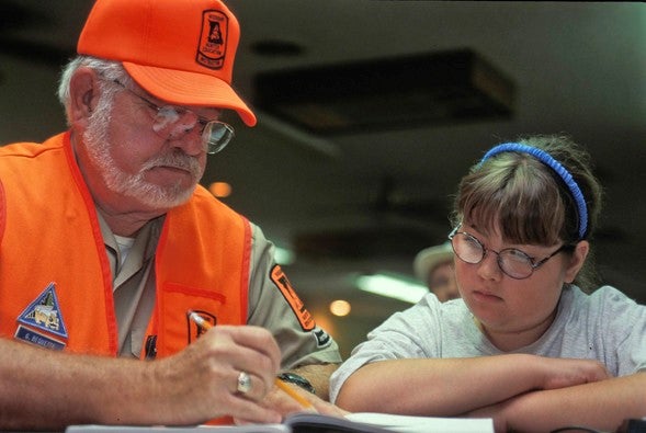 man teaches hunter education to girl