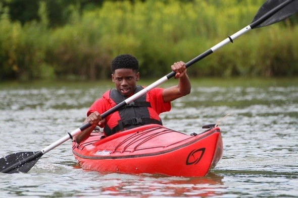 Boy kayaking on lake