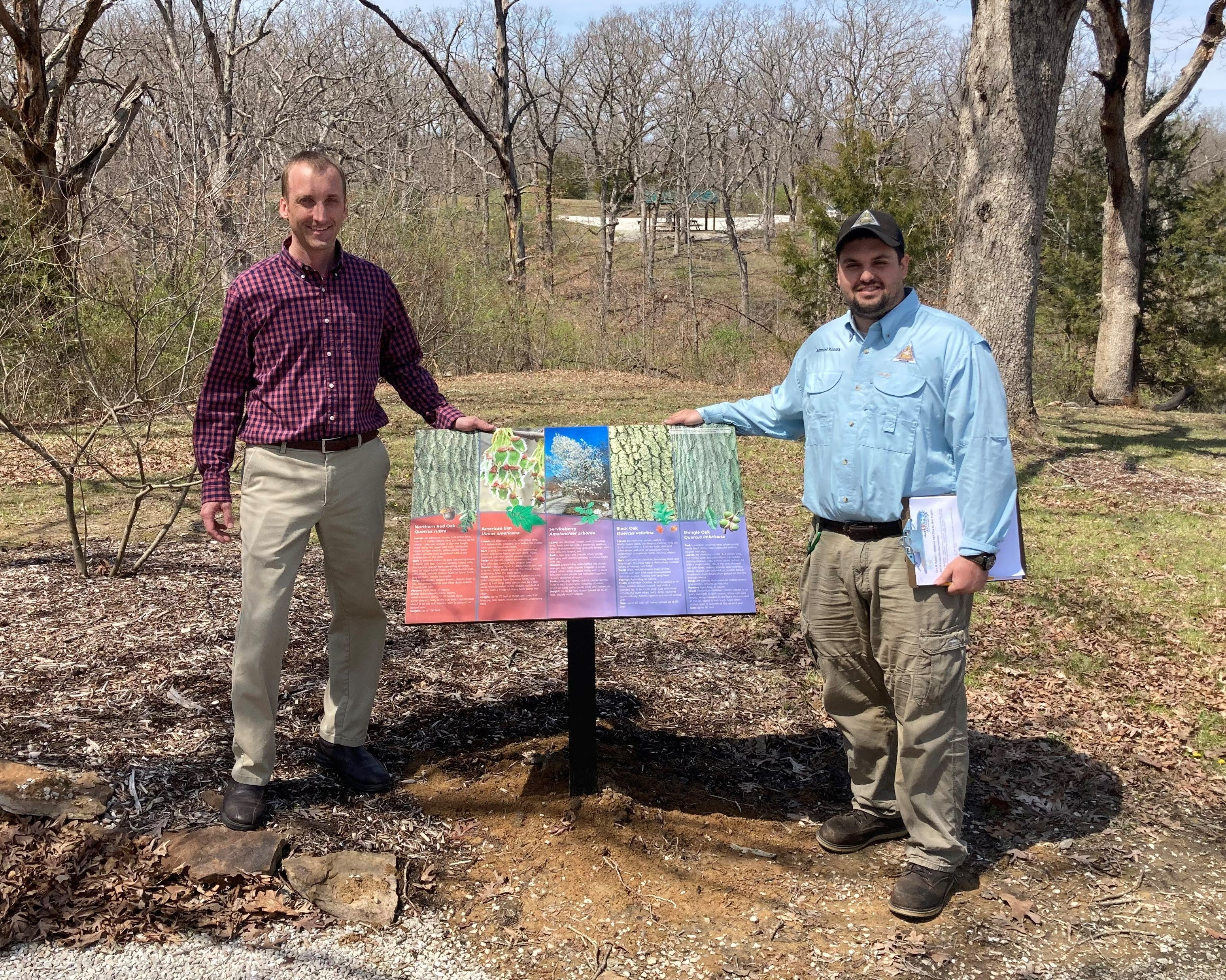 Troy Bock with Sam Kosark next to tree ID sign