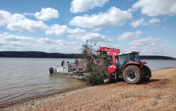 Tractor dumps brush pile in Truman Lake