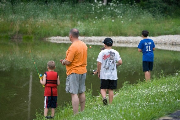 Man and boys fishing at a lake