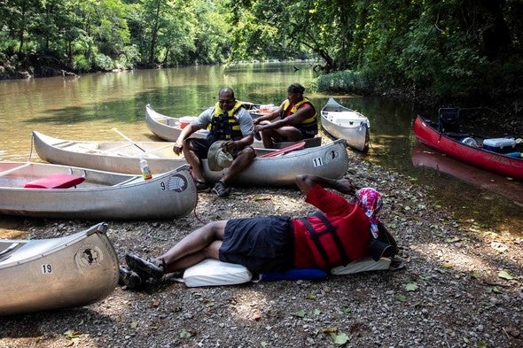 People relaxing on river bank
