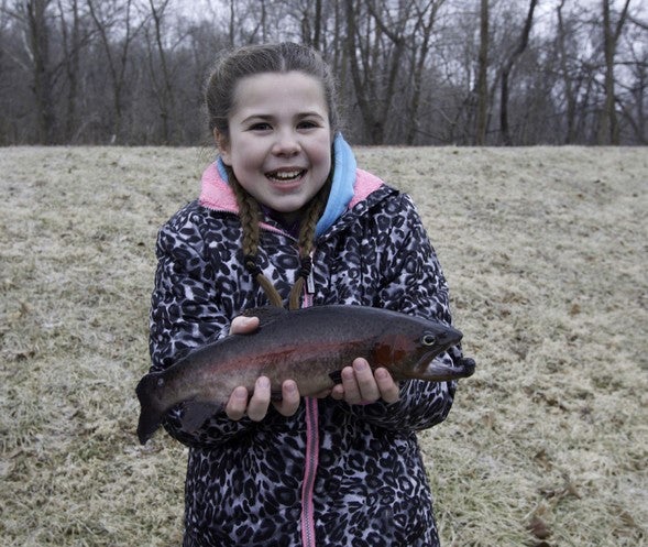 Girl holds rainbow trout