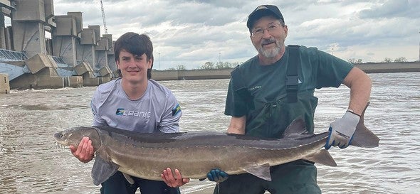 Gavin Stukenburg and MDC biologist hold lake sturgeon