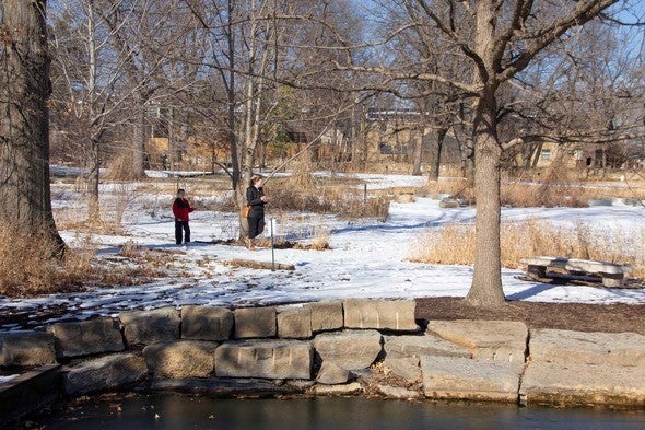 Two people walk outside of the Gorman Discovery Center in winter