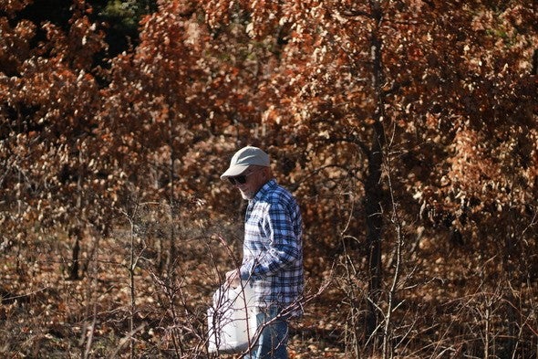 Naturalist spreads native seeds on a prairie site