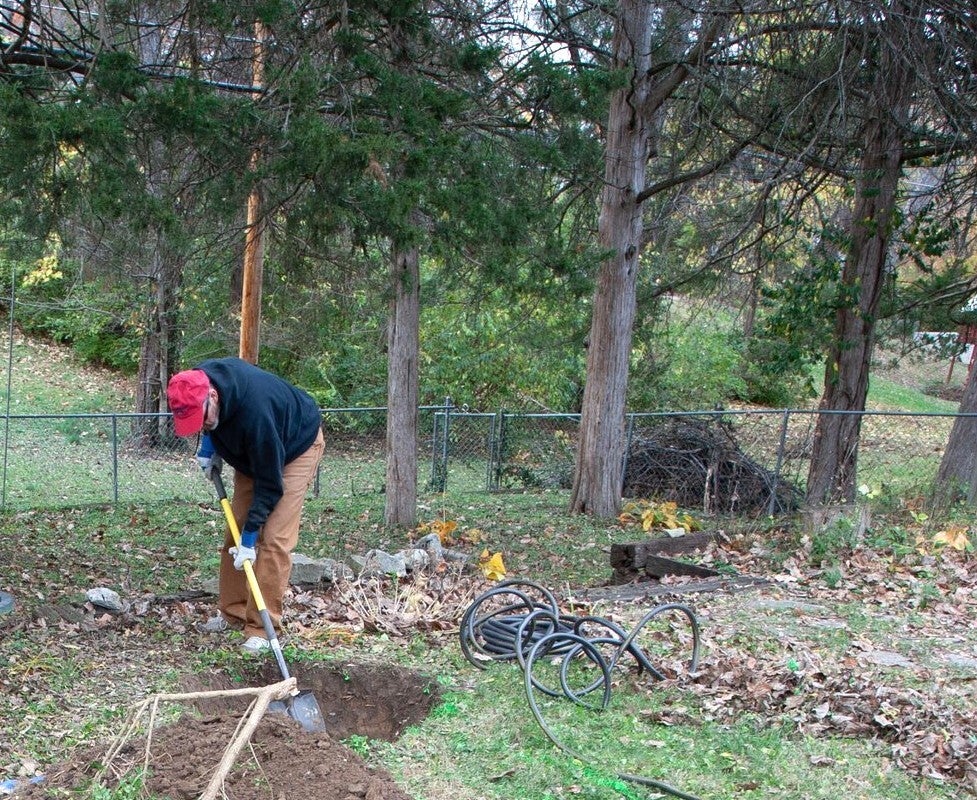 A man preps his native garden in the fall season