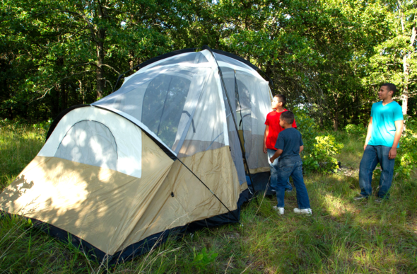Man and two boys set up tent