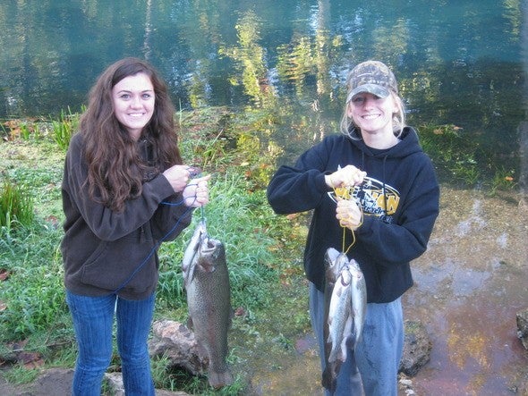 Two women hold trout