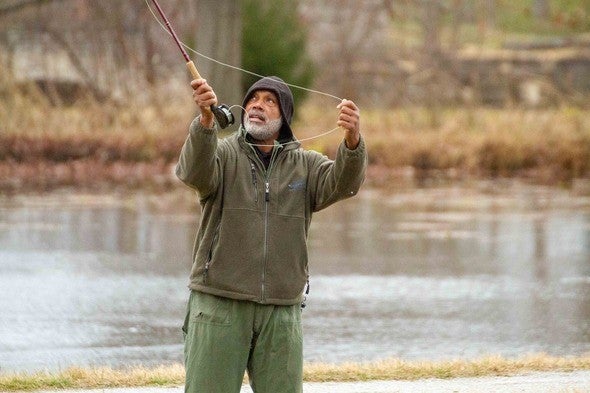 A man fly fishing for trout in the winter