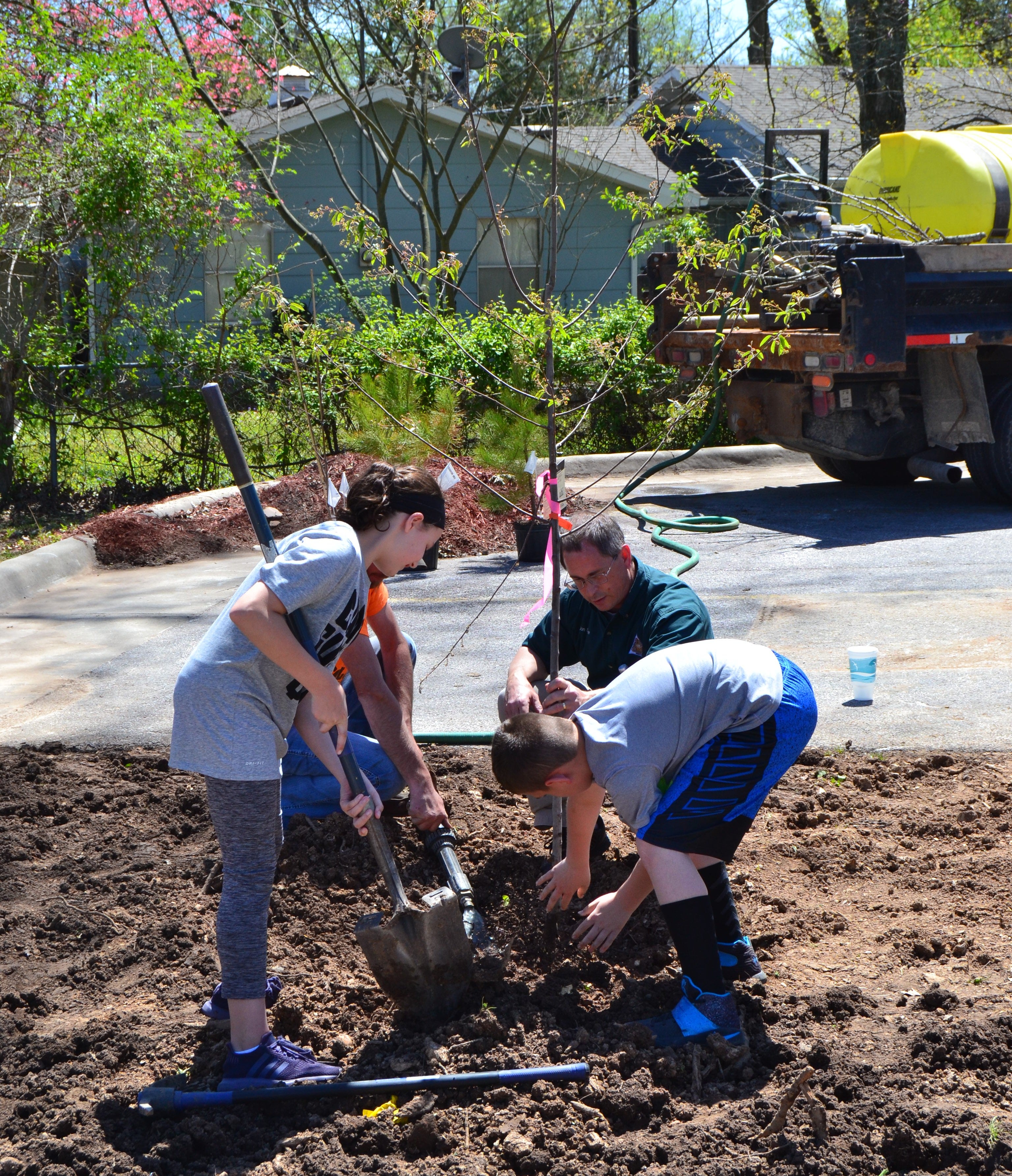 Jon Skinner helping kids plant a native serviceberry tree