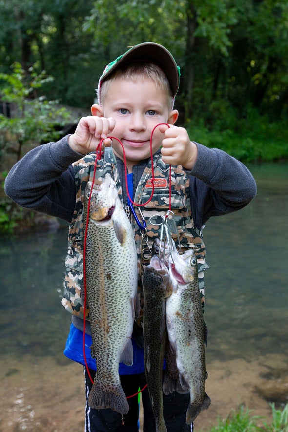 boy holding two trout