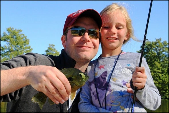 father and daughter with caught fish