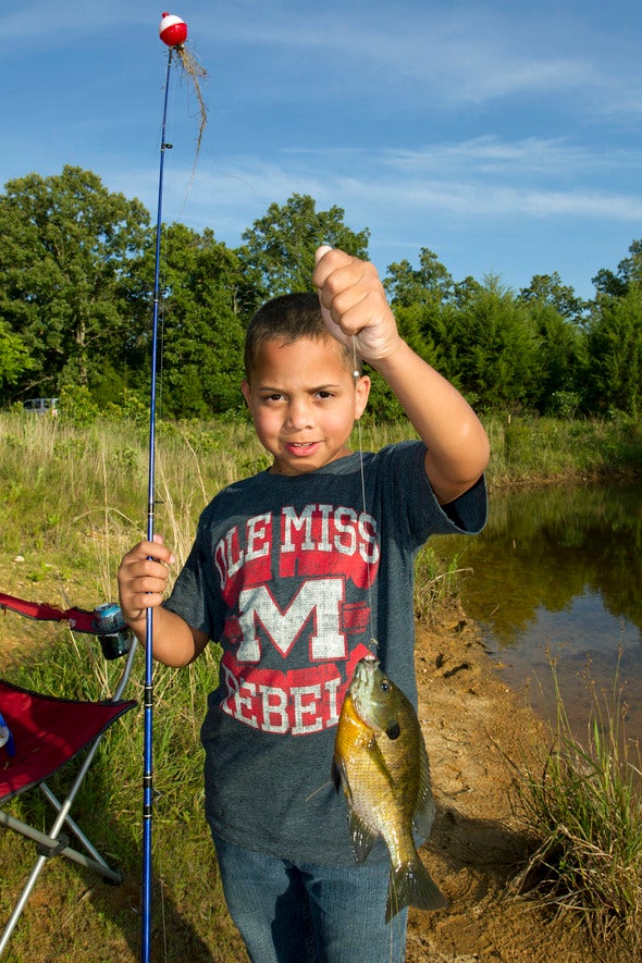 kid with fishing pole holding fish