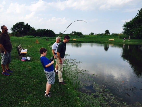 Family fishing in a pond.