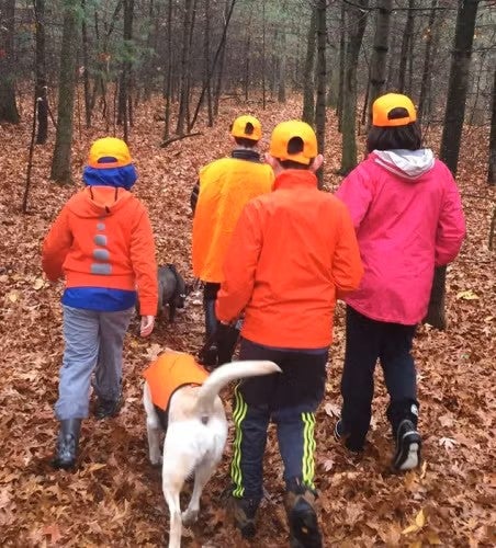 people and dog walking in woods
