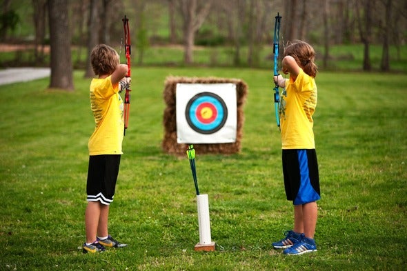 two kids practice archery