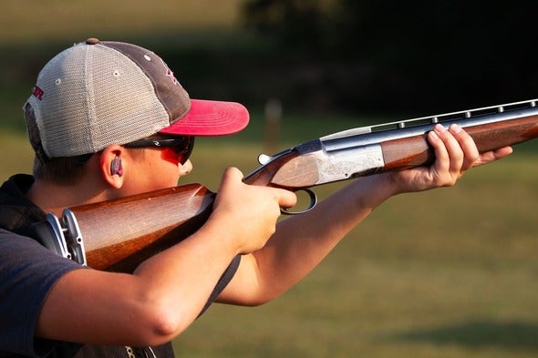 person shooting shotgun