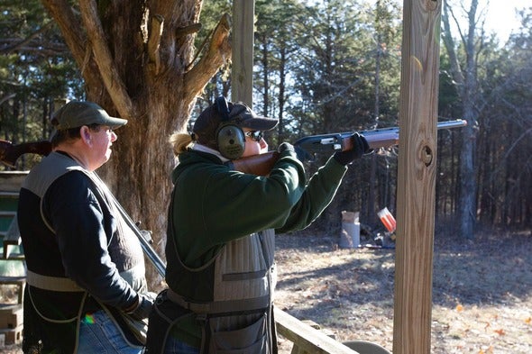 person shooting shotgun