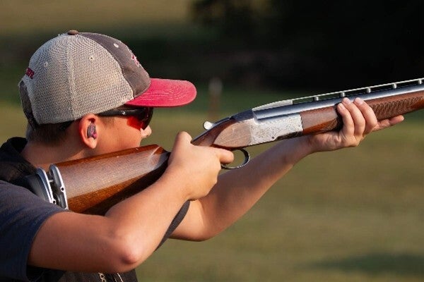 person shooting shotgun