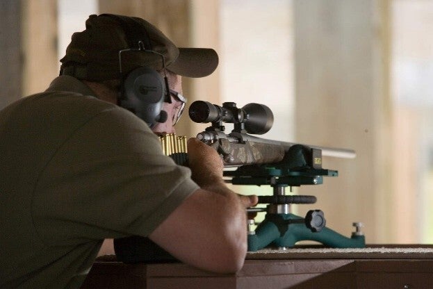 person sighting in a rifle
