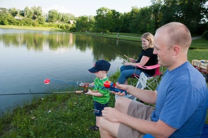 family fishing at pond