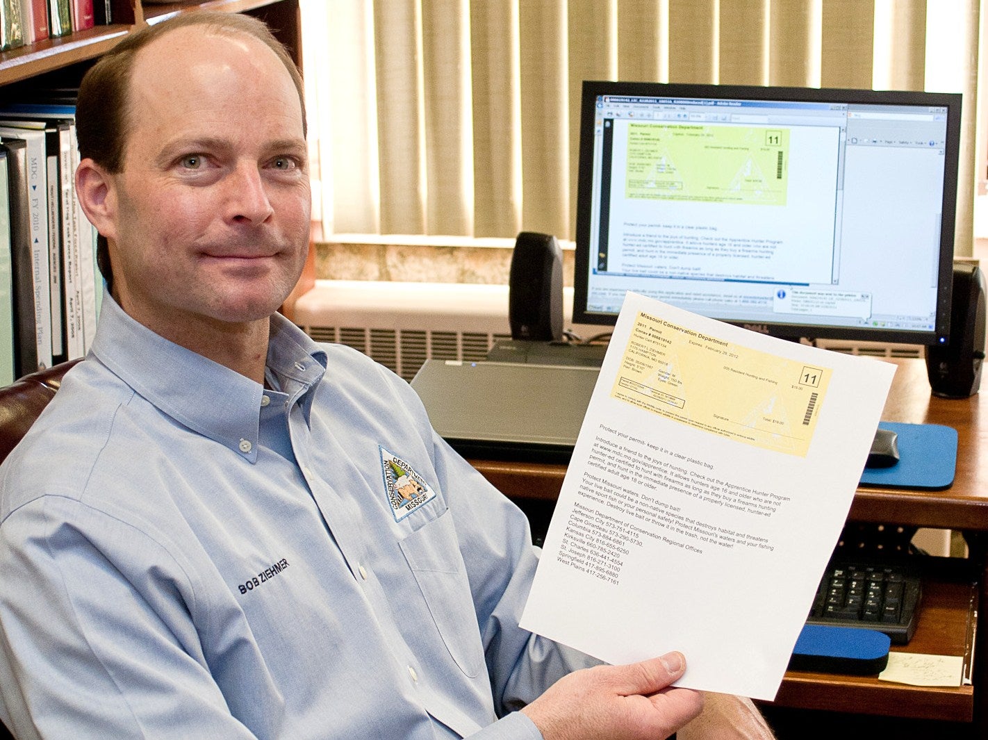 Bob Ziehmer hold an e-permit printed in his office. 