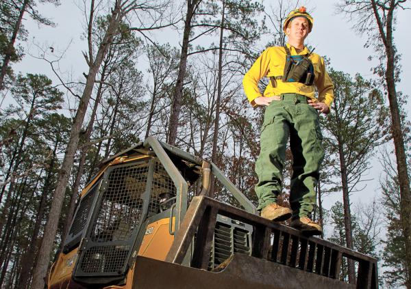 Sam Jewett stands on bulldozer he uses to fight wildfires