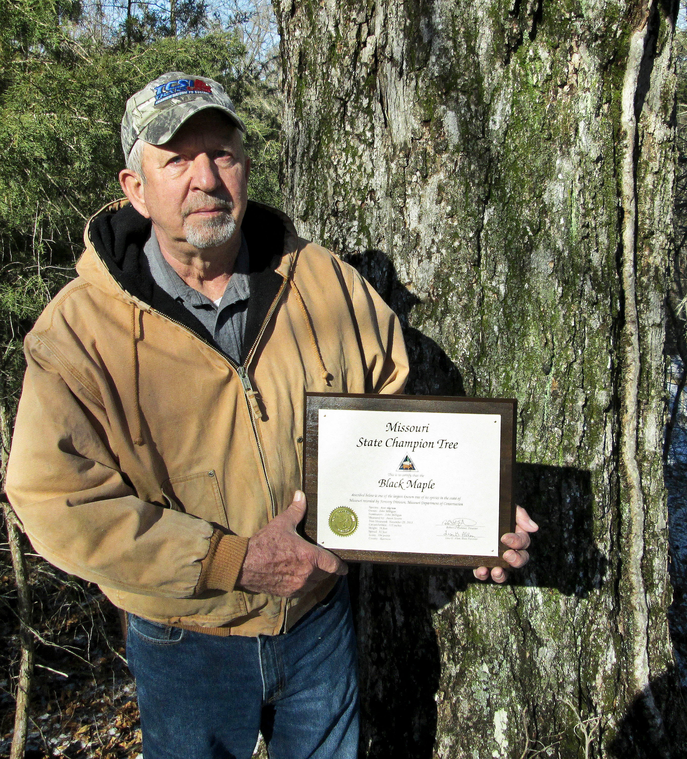 John Milligan with plaque for state champion black maple tree