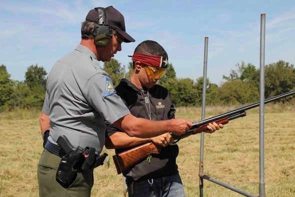 Conservation agent teaches boy to shoot