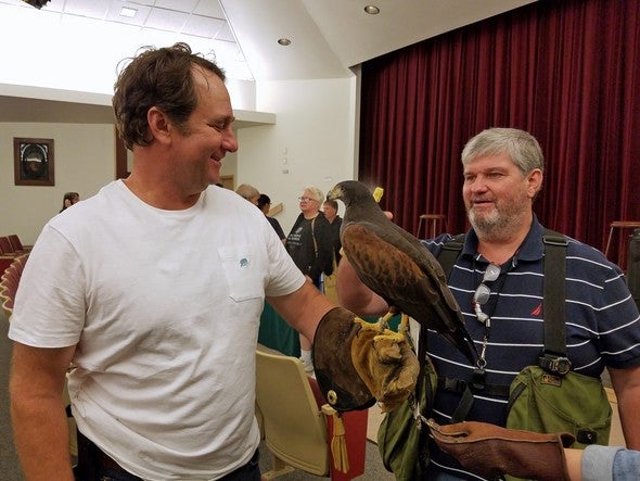 man holding a falcon on glove