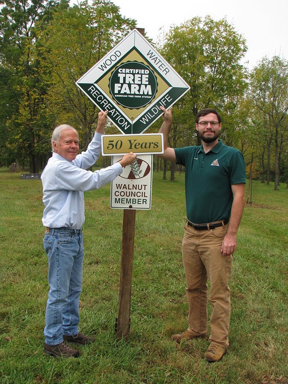 Man getting award from MDC forester for 50 Years in the Tree Farm System