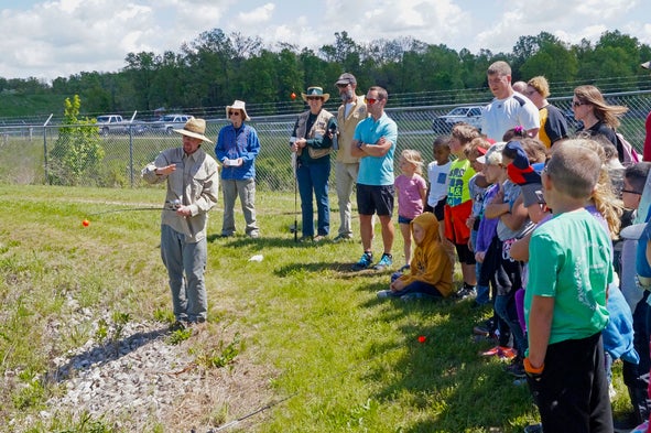 MDC volunteer teaching a group of people about fishing.