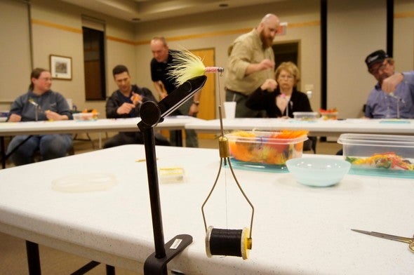 MDC staff teach participants how to tie flies during a workshop.