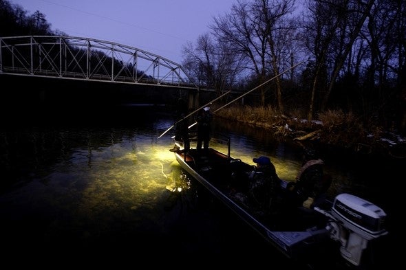 People in a boat gigging.