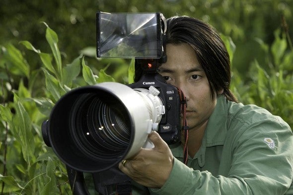Nature photographer Noppadol Paothong holds his camera.