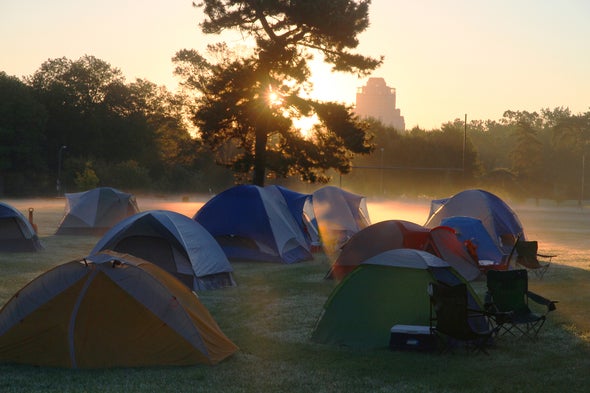 Sunrise behind tents in a field