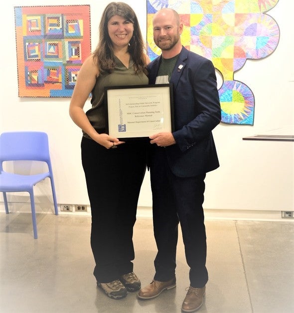 Community Conservation Planner Ronda Burnett poses with the Outstanding Initiative Award with Missouri APA Chapter President Jason Ray.