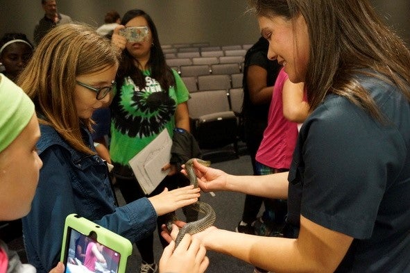 Runge volunteer showing snake to kids