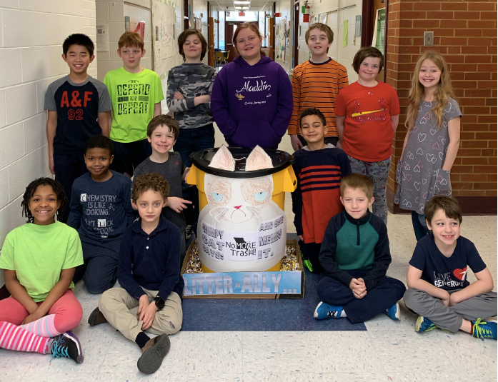 students posing with winning trashcan