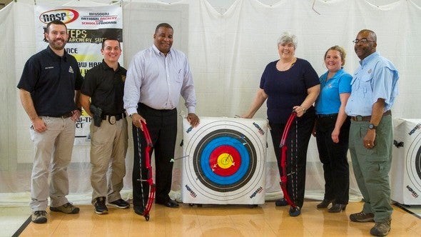group of people posed with archery equipment