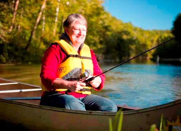 Woman fishing from canoe