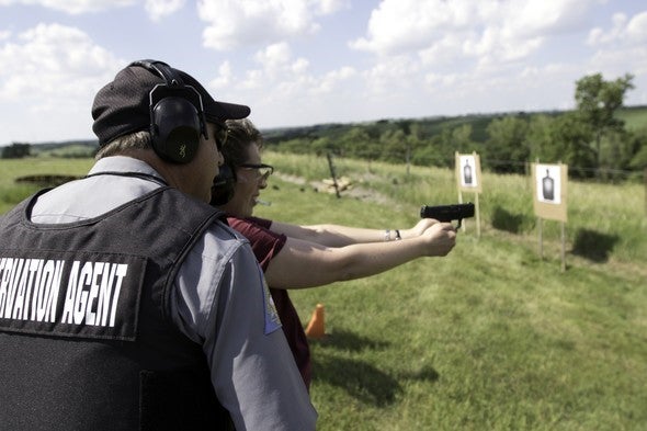 agent teaching woman to shoot handgun